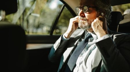an-older-businessman-putting-on-headphones-prepares-for-a-conference-call-.jpg